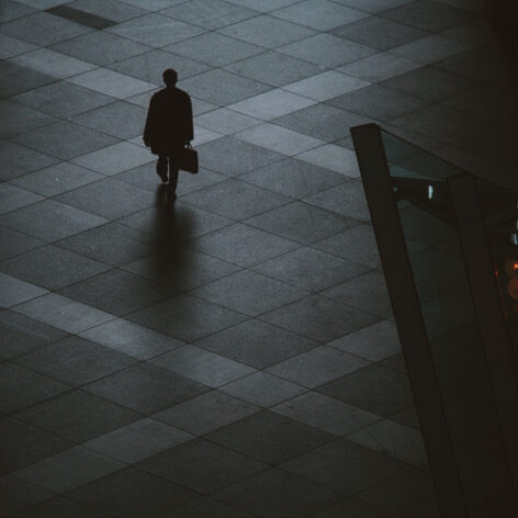Person Walking on Brown Floor Tiles